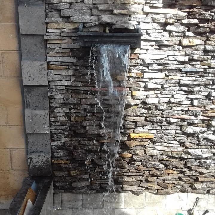 Muro con cascada en tira de piedra
